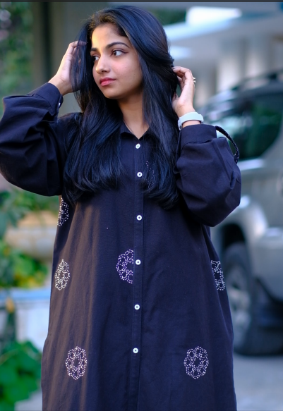 Timeless black button-down shirt adorned with delicate white embroidery, offering a chic and elegant look for any occasion.