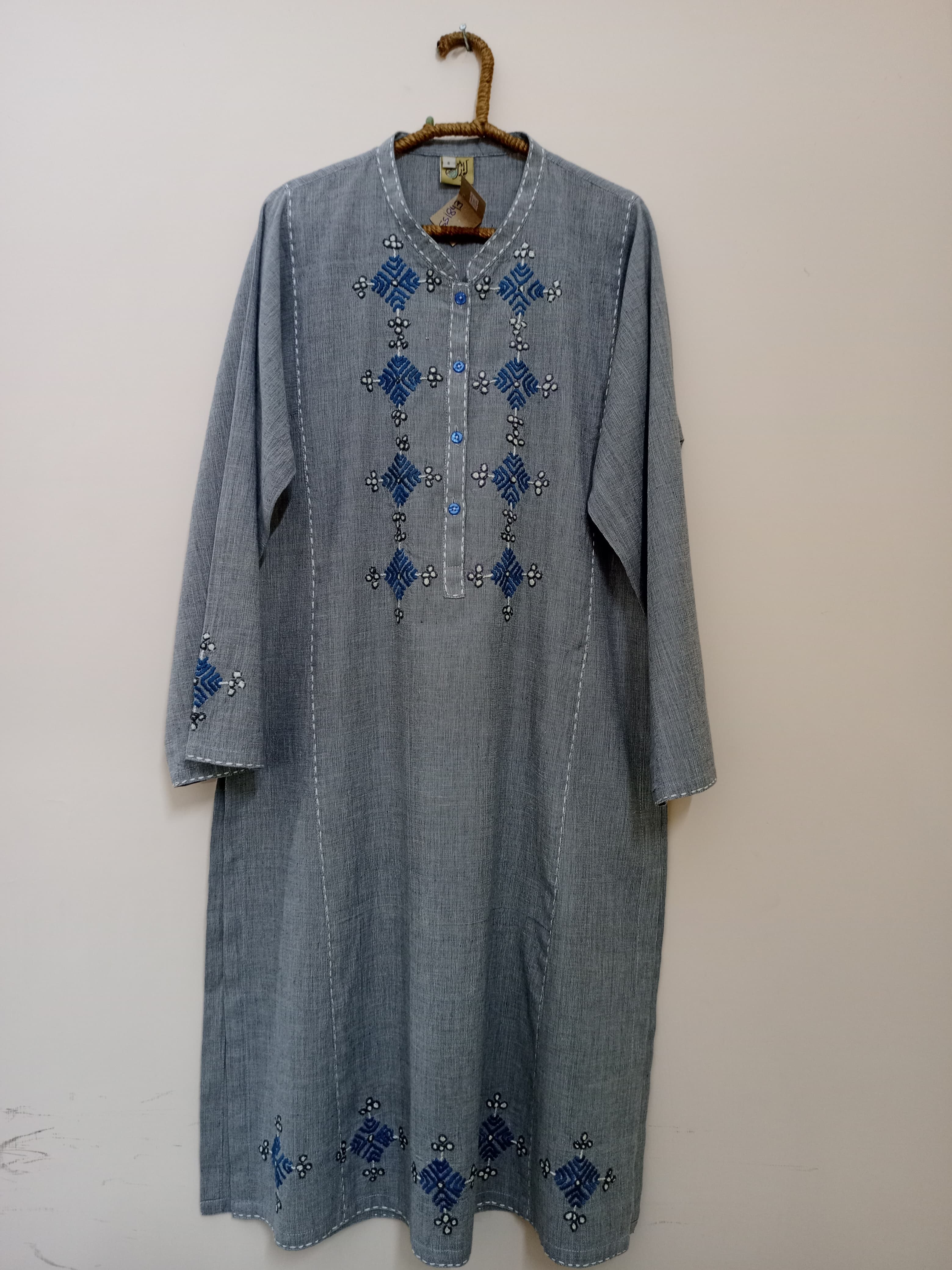 A deep-toned shirt with soft hand embroidery detailing on neckline, sleeve borders, and hem. Perfect for everyday elegance with a touch of handcrafted charm.