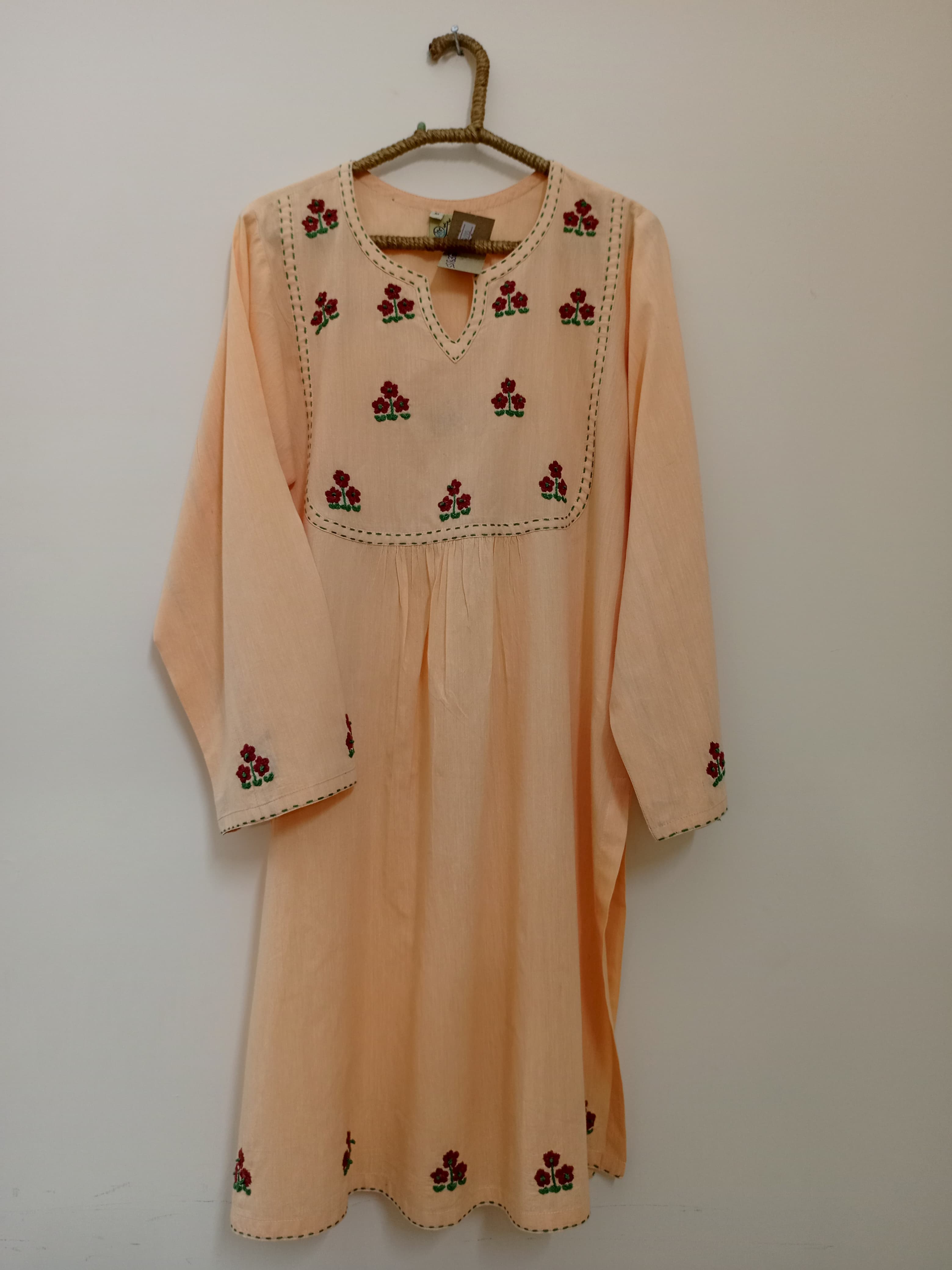 A beautifully detailed hand-embroidered shirt featuring a soft neckline pattern and a bordered finish. The delicate design makes it a timeless addition to any subtle wardrobe.